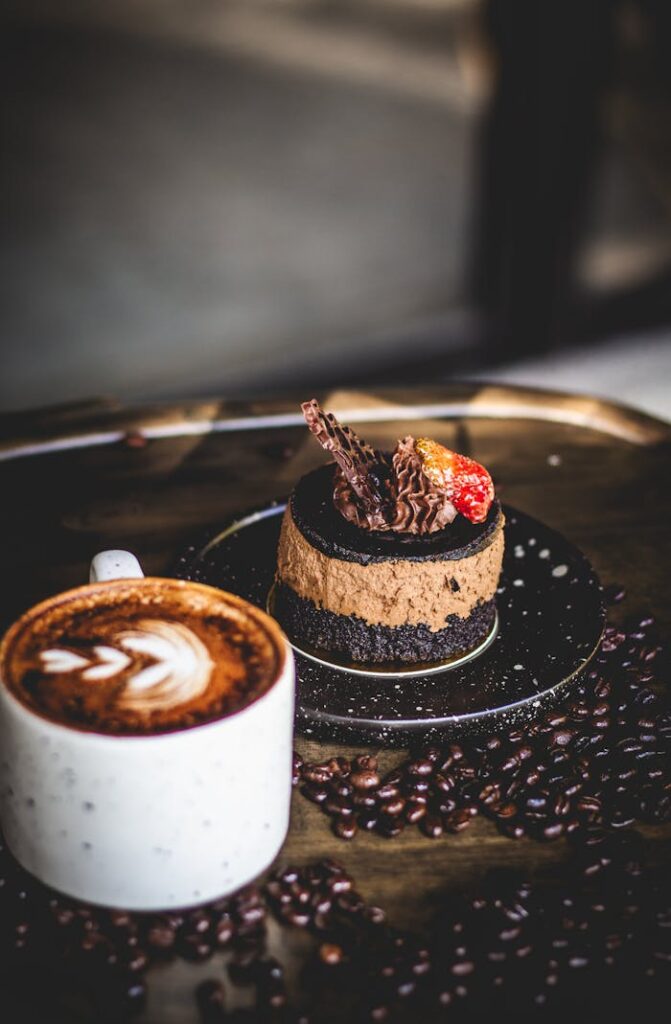 pexels photo 14630365 Indulge in a gourmet coffee with chocolate dessert, beautifully styled on a tray of coffee beans.