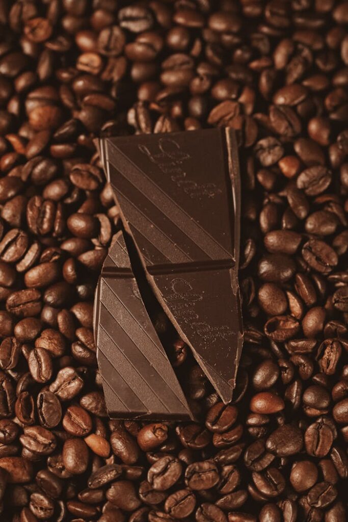 pexels photo 27047941 Top view of dark chocolate on freshly roasted coffee beans, perfect for food enthusiasts.