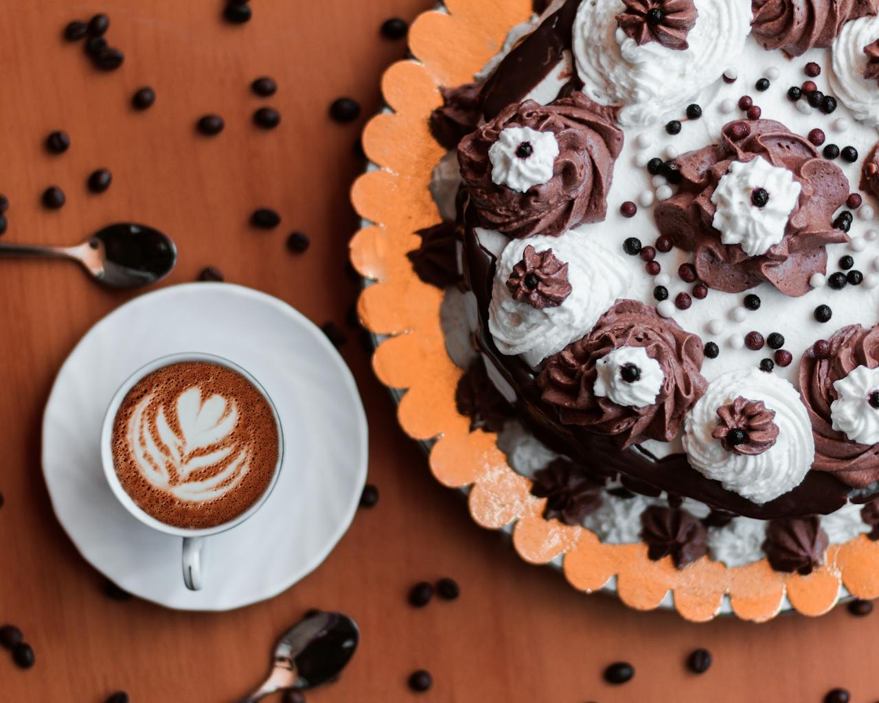 Indulge in a rich chocolate cake paired with a frothy latte, perfect for dessert lovers.