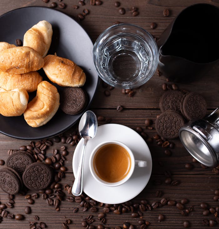pexels photo 6006670 Top view arrangement of aromatic hot espresso in cup served on wooden table amidst coffee beans and chocolate cookies in modern cafe
