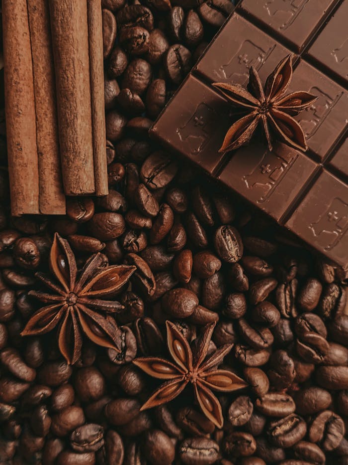 pexels photo 8820618 Chocolate, star anise, and cinnamon on coffee beans creating a warm, aromatic composition.